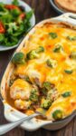 cheesy broccoli chicken casserole in a baking dish on a wooden table, served with a side salad.